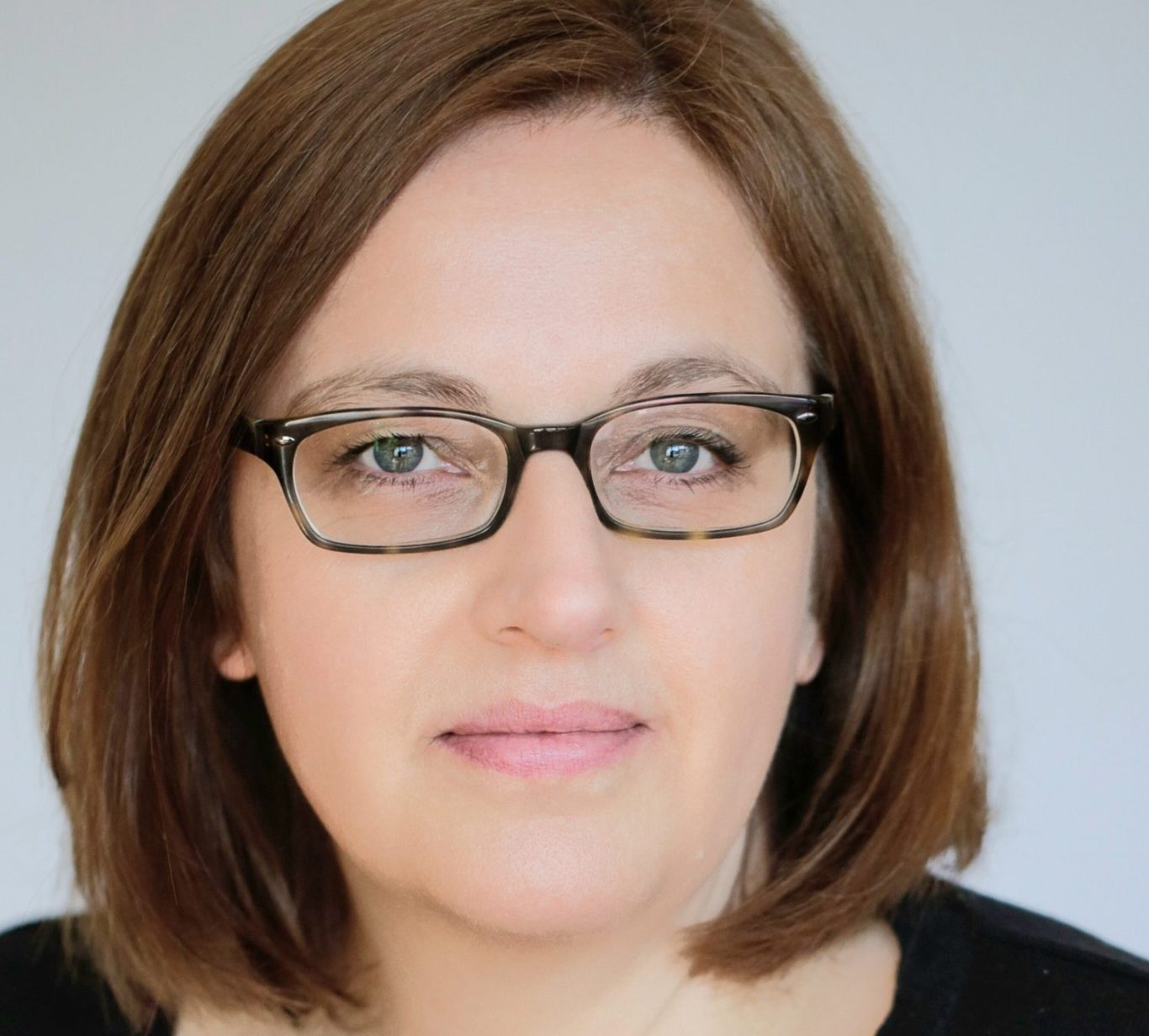 Portraitbild von Beate Kriechel - Autorin & Referentin Porträt von Beate Kriechel mit Brille und schulterlangen braunen Haaren, neutraler Hintergrund.